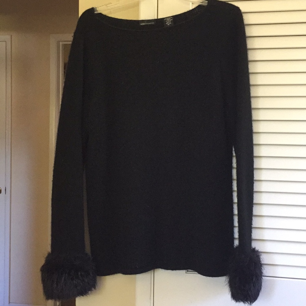 Sweater with fake fur on bottom of sleeves.
